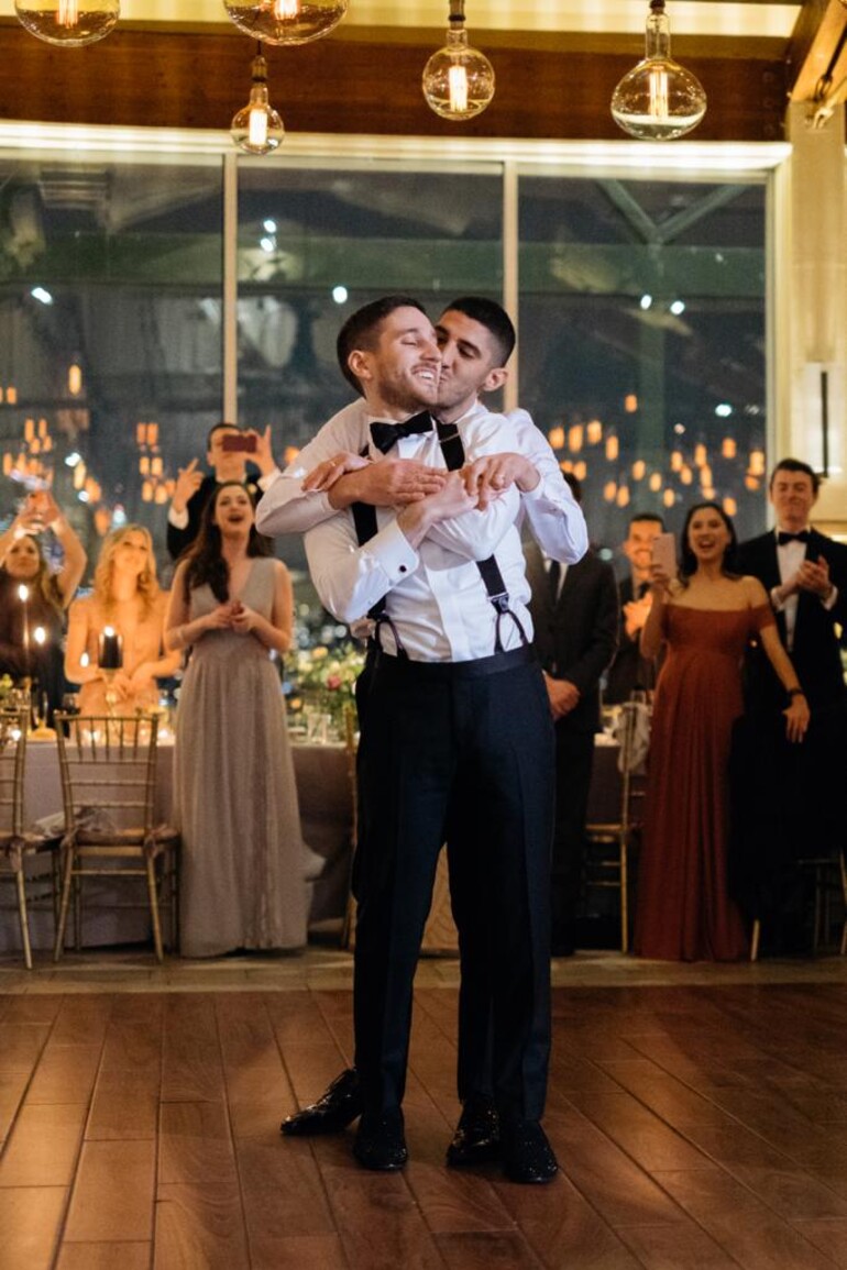 Two grooms embracing on the dance floor